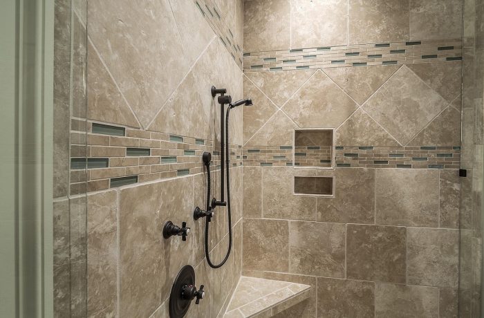 A tiled shower enclosure wall, the surface a grab bar has to be anchored through