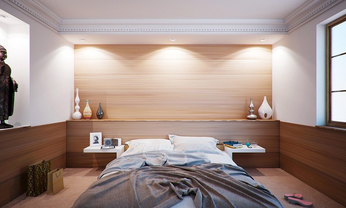 A spare bedroom set up with a bed, ready for someone moving in