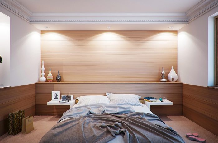 A spare bedroom set up with a bed, ready for someone moving in